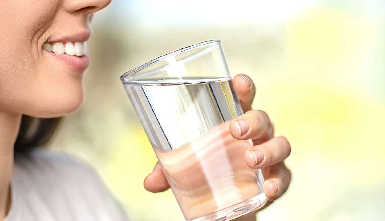 a girl drinking water in a glass