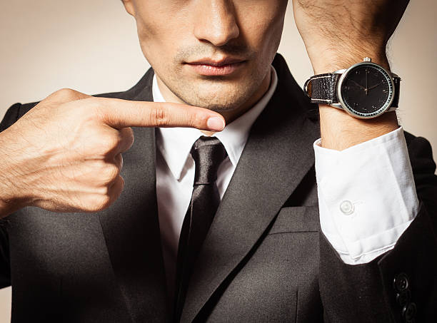 Businessman showing time on his wrist watch.