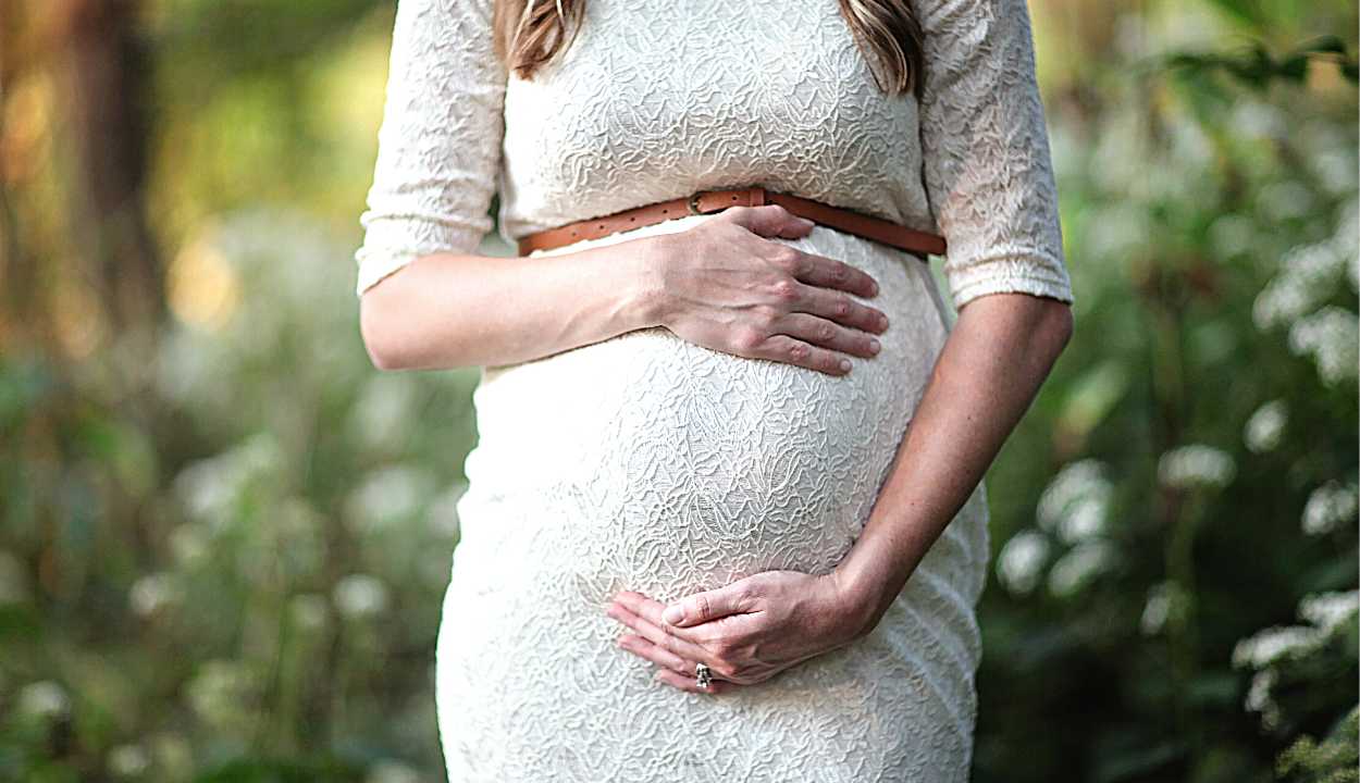 a pregnant woman holding her baby bump