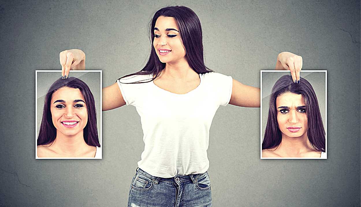 woman holding pictures with good and bad emotions having mood swings and smiling at positive herself