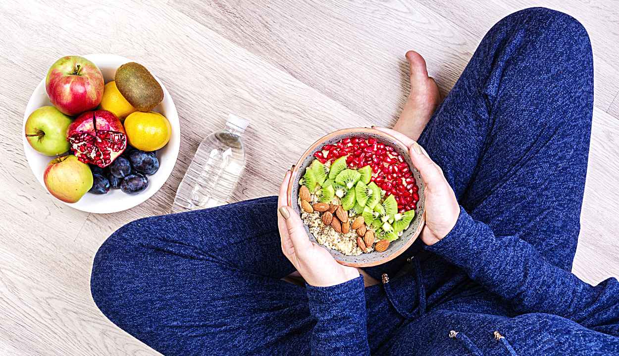 a girl having a bowl of oatmeal and a bowl of fruits