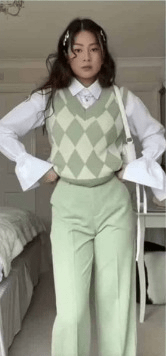a girl wearing a white shirt and sage green sweater and sage green pants